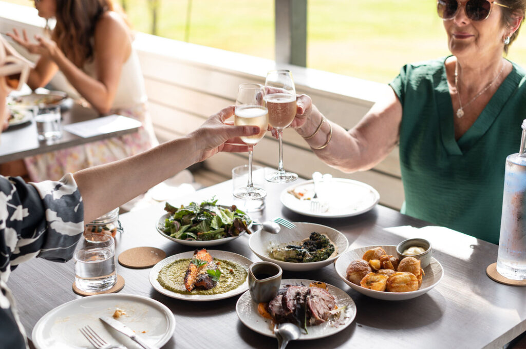 Couple cheersing their wine over a shared meal